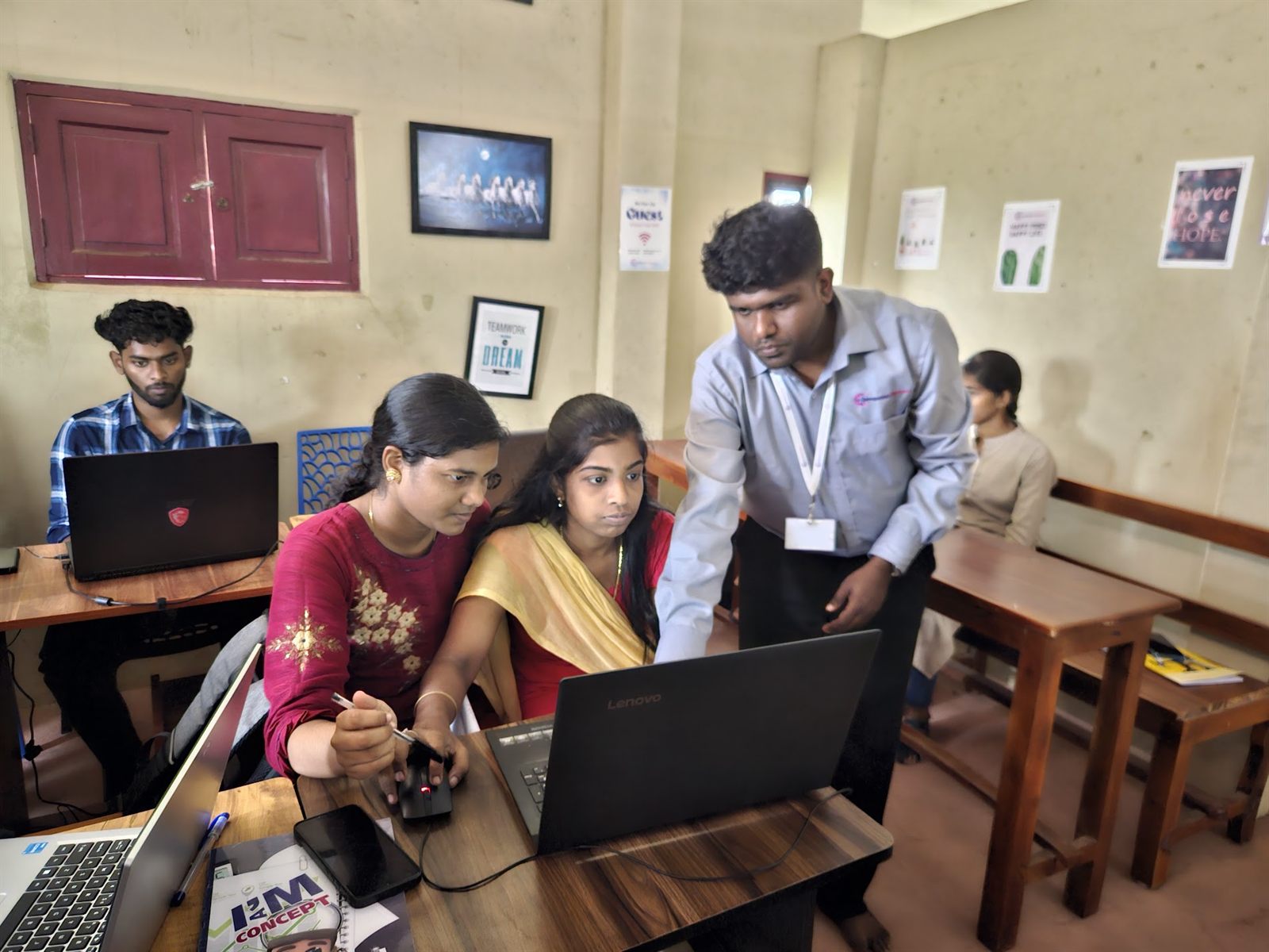 Dr. Aran Castro guiding two students through a GIS workflow on a laptop in the Nagercoil studio